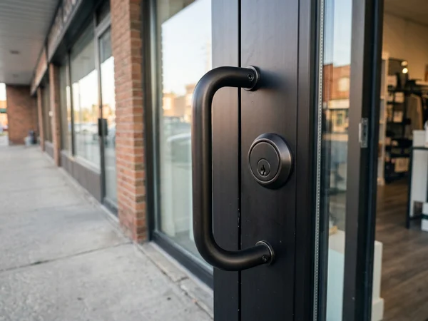 Finish-matched pull handle and cylinder on a replaced boutique door