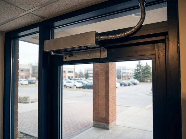 Magnetic lock on the header of an aluminum entrance door